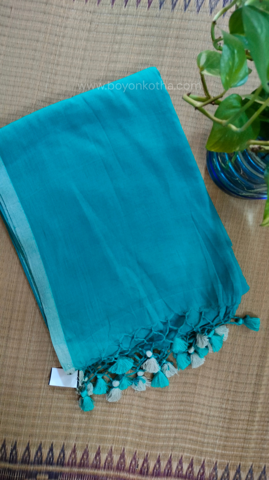 Turquoise blue handwoven mul cotton saree with grey border, pallu ending in tassels. Plain handloom saree from Bengal.