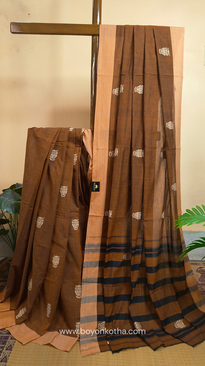 Rust Dhonekhali handloom cotton saree adorned with woven owl motifs in beige across the body and pallu. Perfect for casual gatherings and everyday elegance.