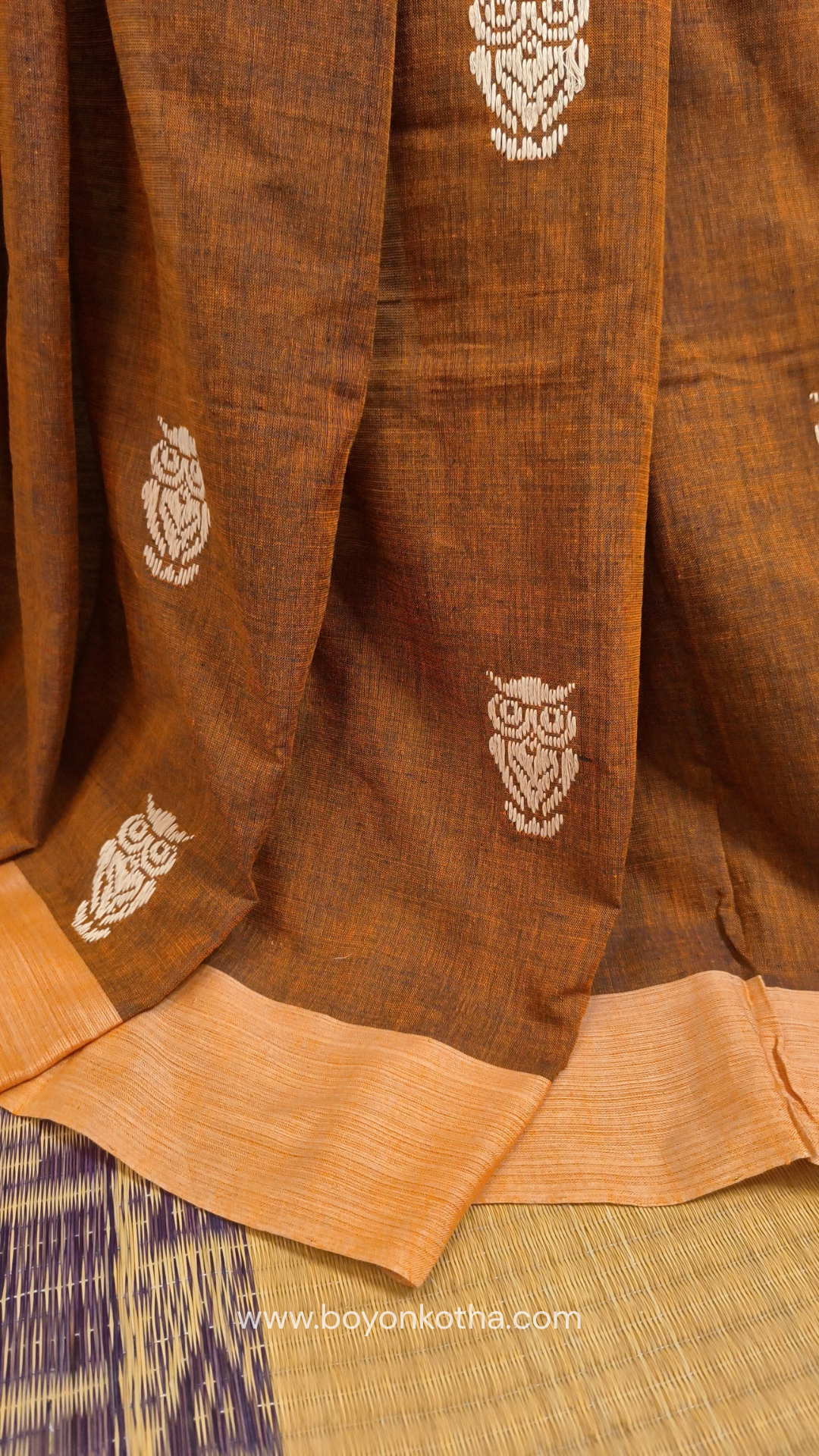 Rust Dhonekhali handloom cotton saree adorned with woven owl motifs in beige across the body and pallu. Perfect for casual gatherings and everyday elegance.