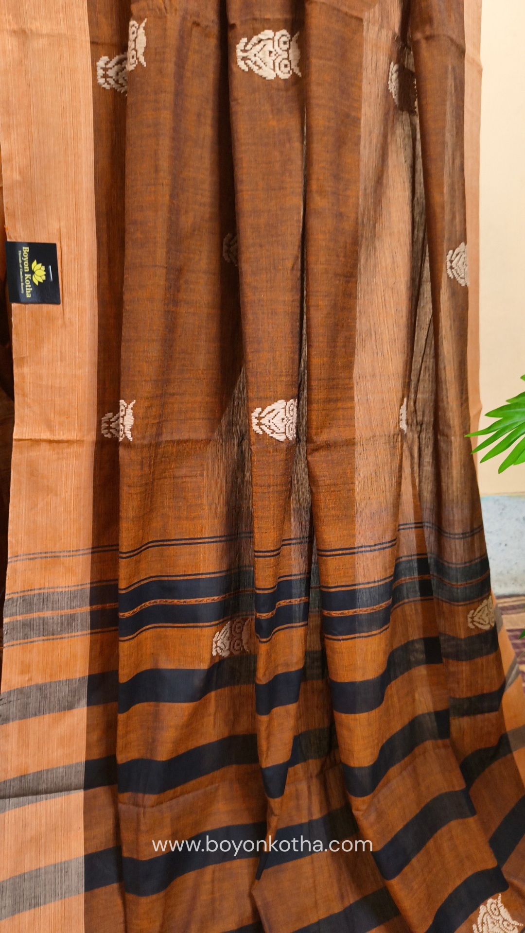 Rust Dhonekhali handloom cotton saree adorned with woven owl motifs in beige across the body and pallu. Perfect for casual gatherings and everyday elegance.
