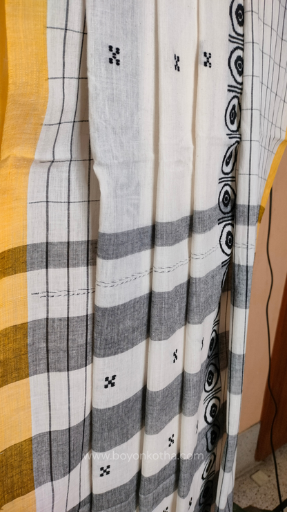 White Dhonekhali handloom cotton saree featuring a delicate yellow border and intricate woven black and yellow motifs. 