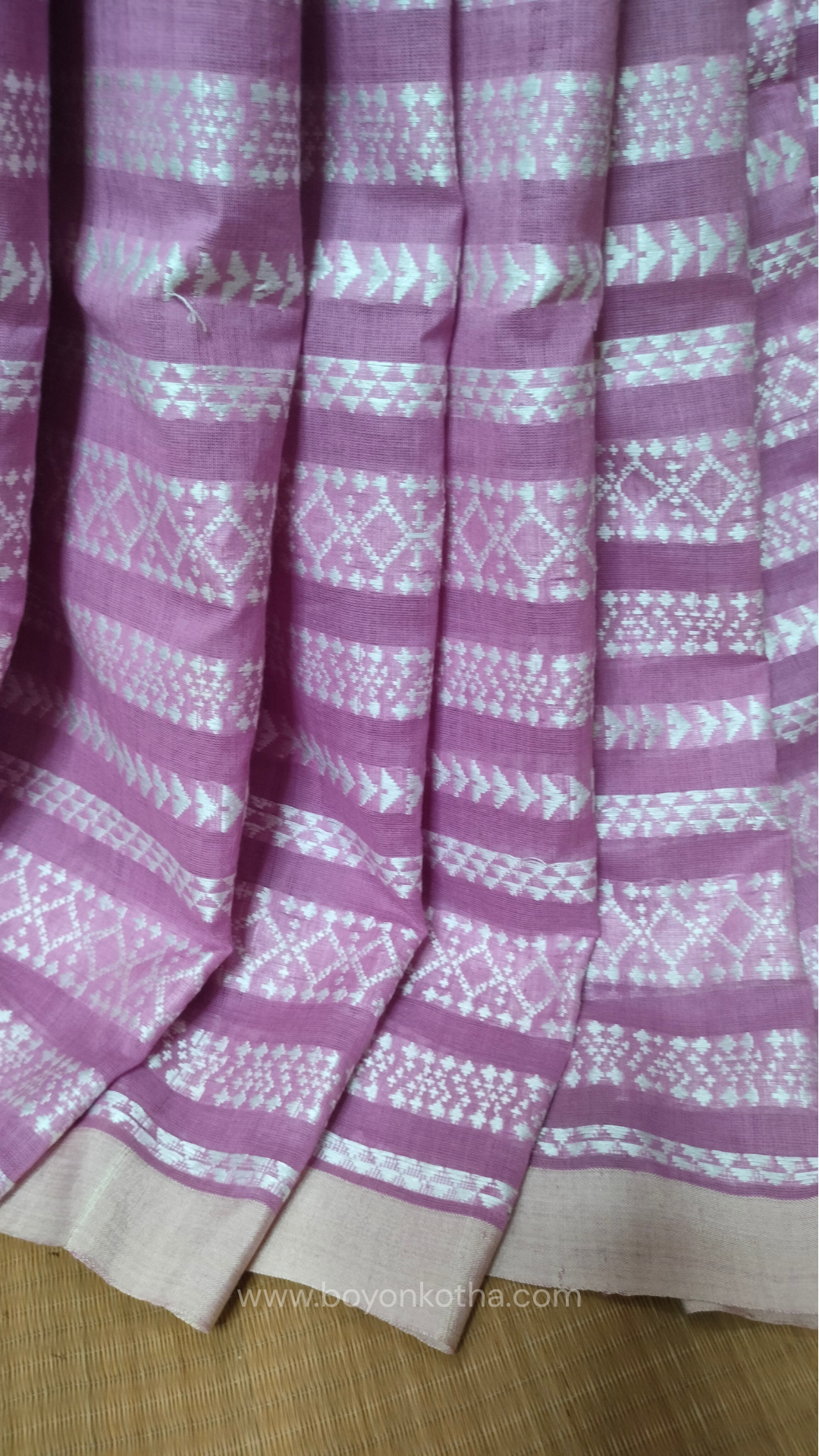 Pink Dhonekhali cotton saree adorned with delicate off-white woven patterns across the saree. Perfect for morning pujas to evening celebrations, for festive occasions