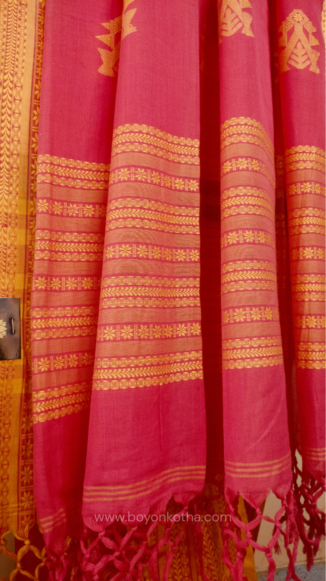 Pink handwoven mercerized cotton saree with Manipuri-inspired thread work pattern in yellow. Durable, breathable Bengal handloom saree for festive wear.