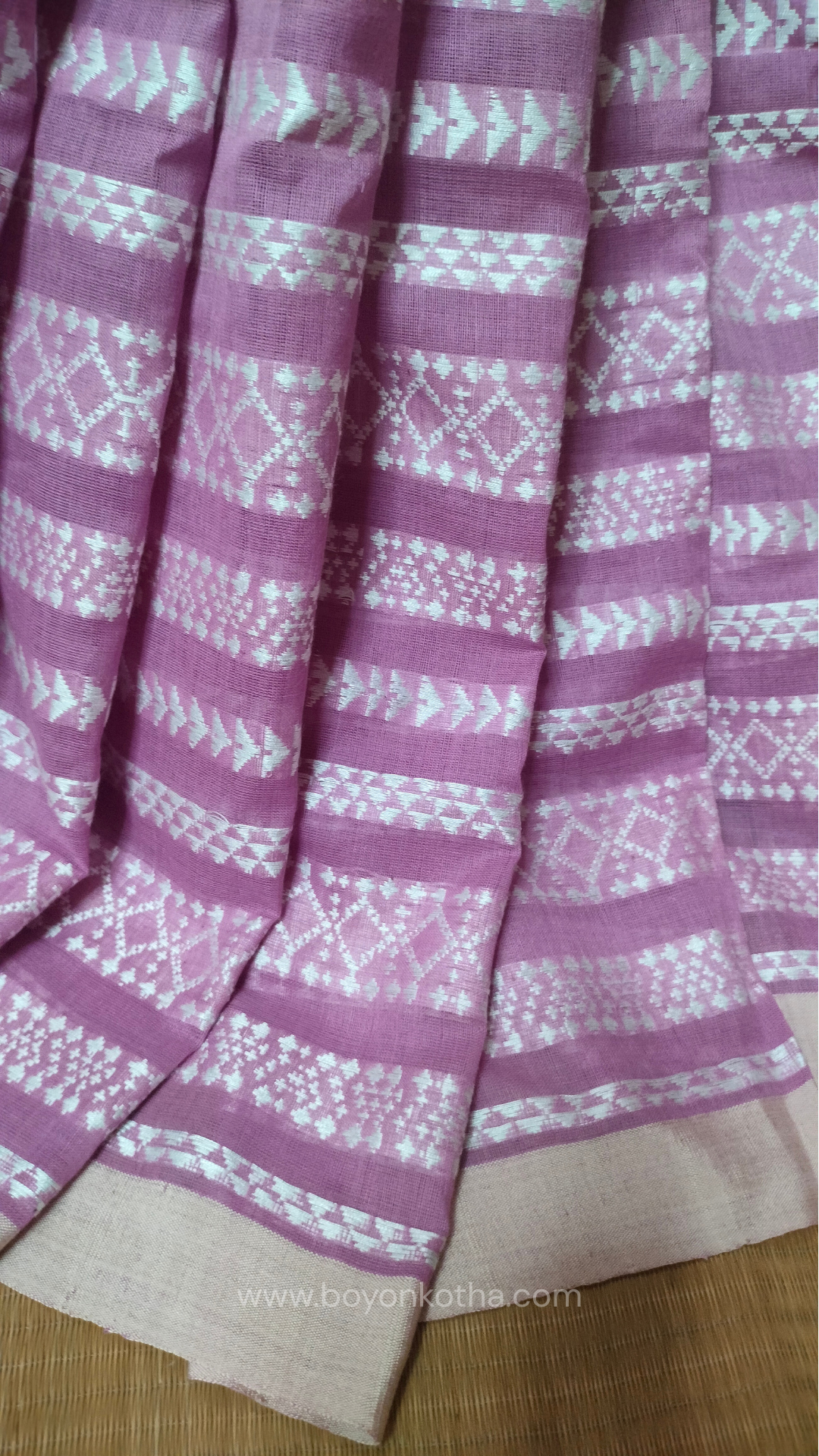 Pink Dhonekhali cotton saree adorned with delicate off-white woven patterns across the saree. Perfect for morning pujas to evening celebrations, for festive occasions