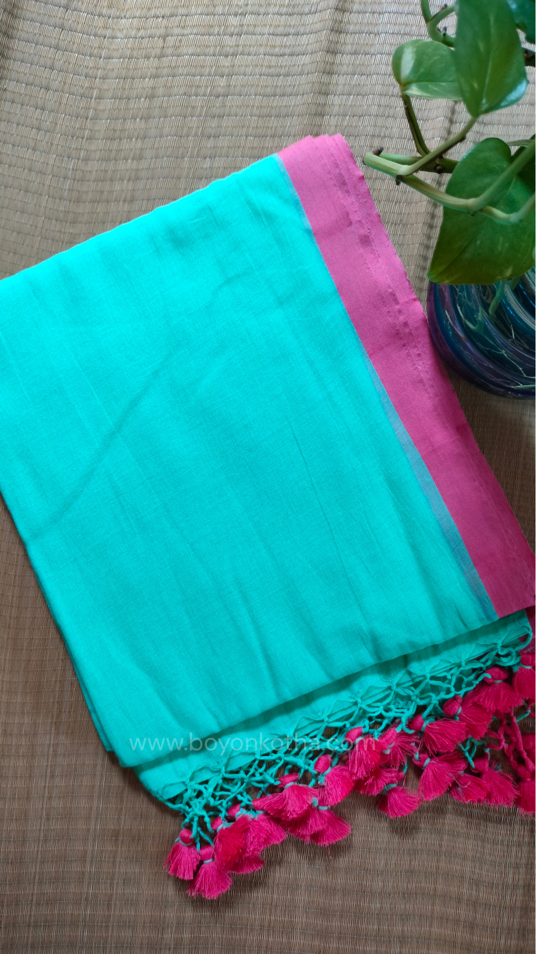 Mint green handwoven mul cotton saree with pink border, pallu ending in tassels. Plain handloom saree from Bengal.