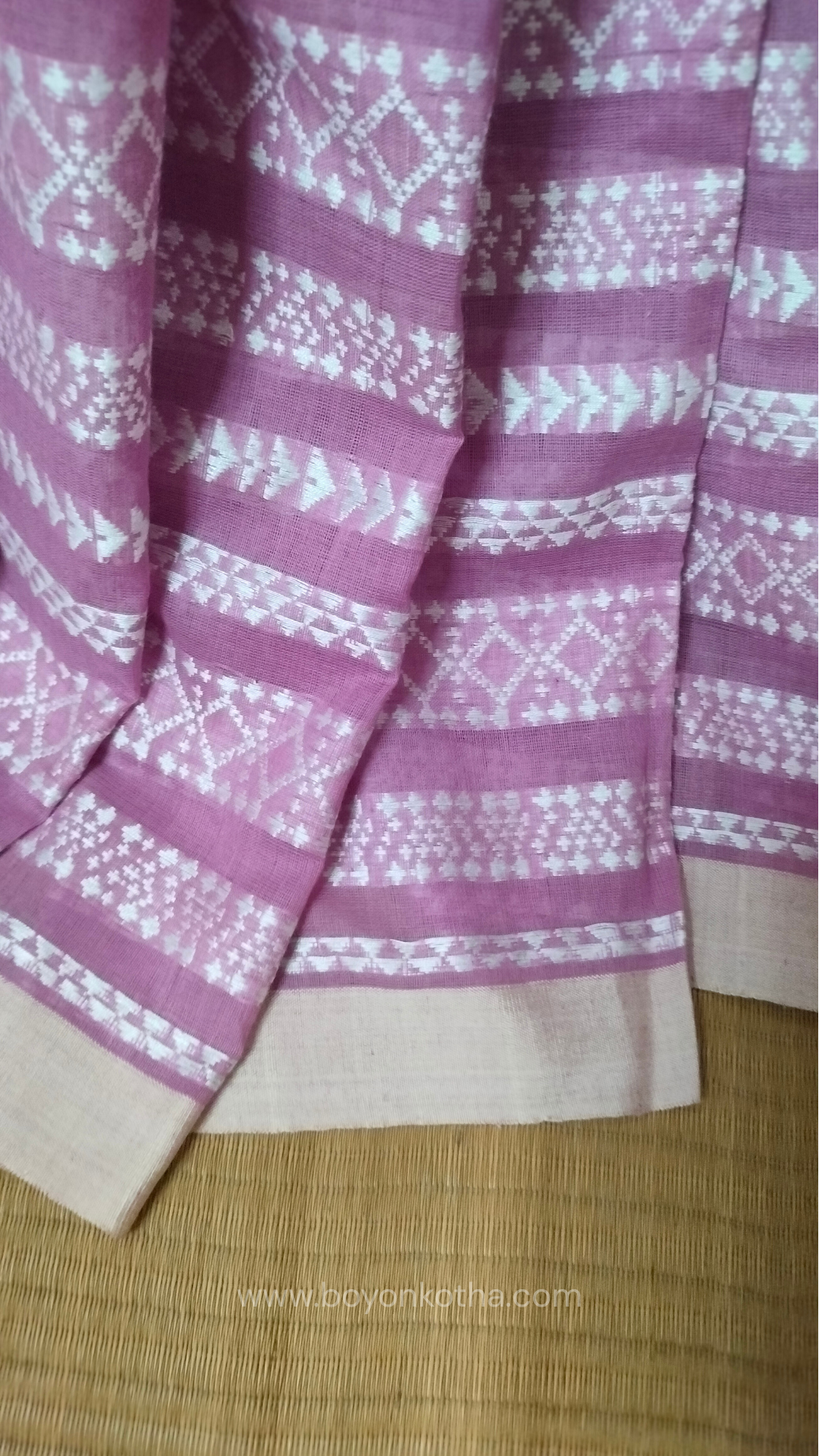 Pink Dhonekhali cotton saree adorned with delicate off-white woven patterns across the saree. Perfect for morning pujas to evening celebrations, for festive occasions