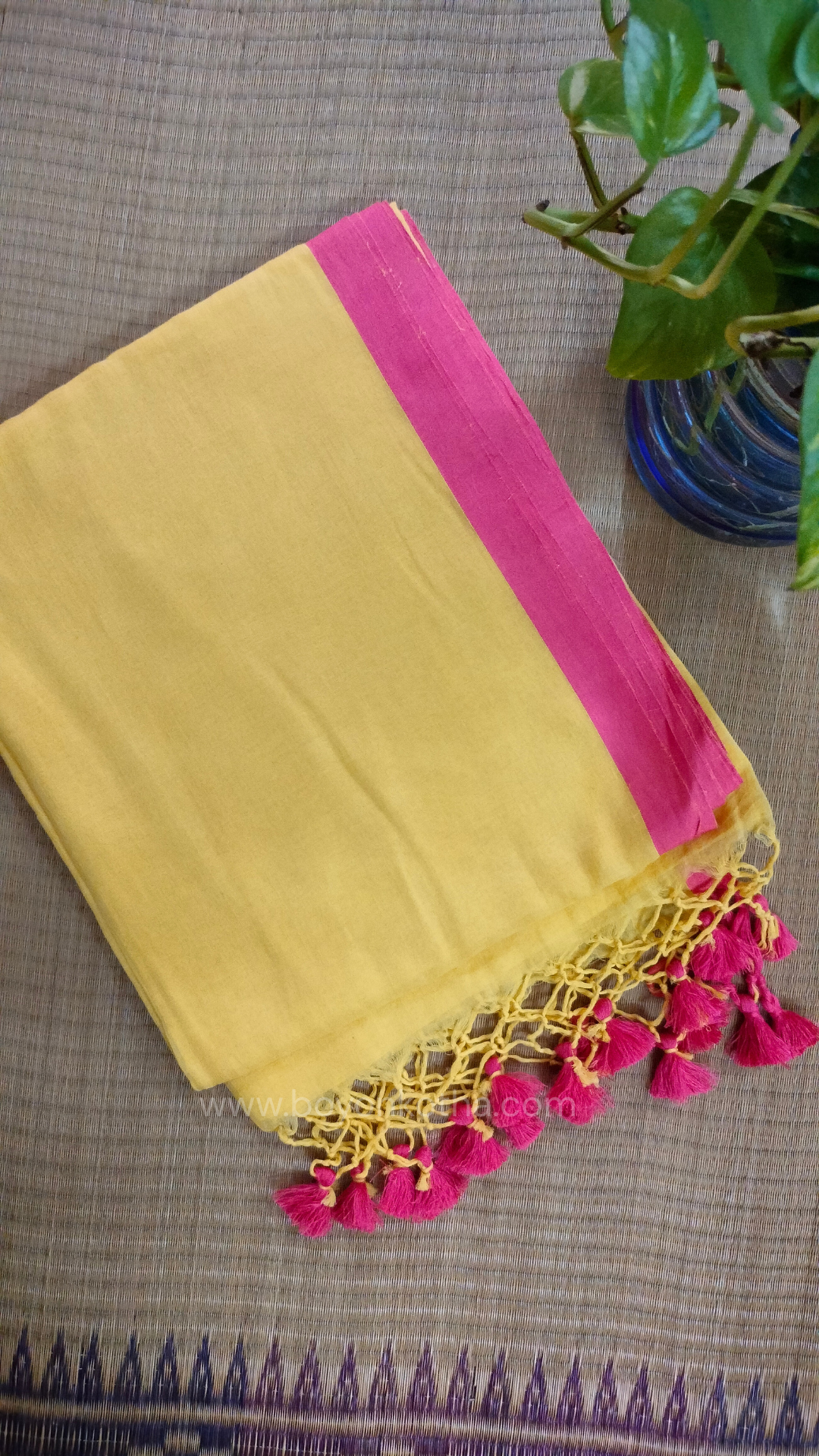 Yellow handwoven mul cotton saree with peach border, pallu ending in tassels. Plain handloom yellow saree from Bengal.