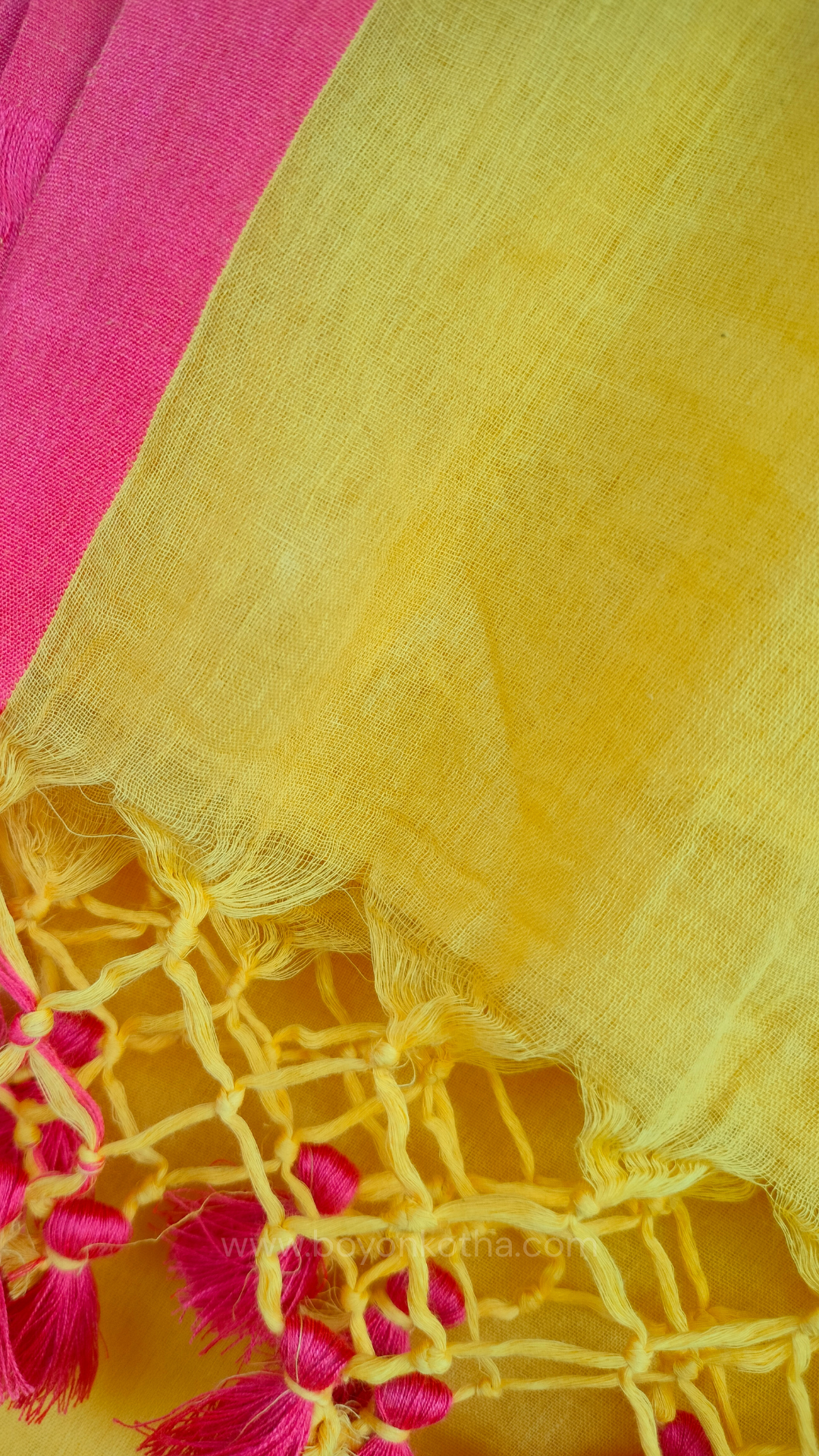 Yellow handwoven mul cotton saree with peach border, pallu ending in tassels. Plain handloom yellow saree from Bengal.
