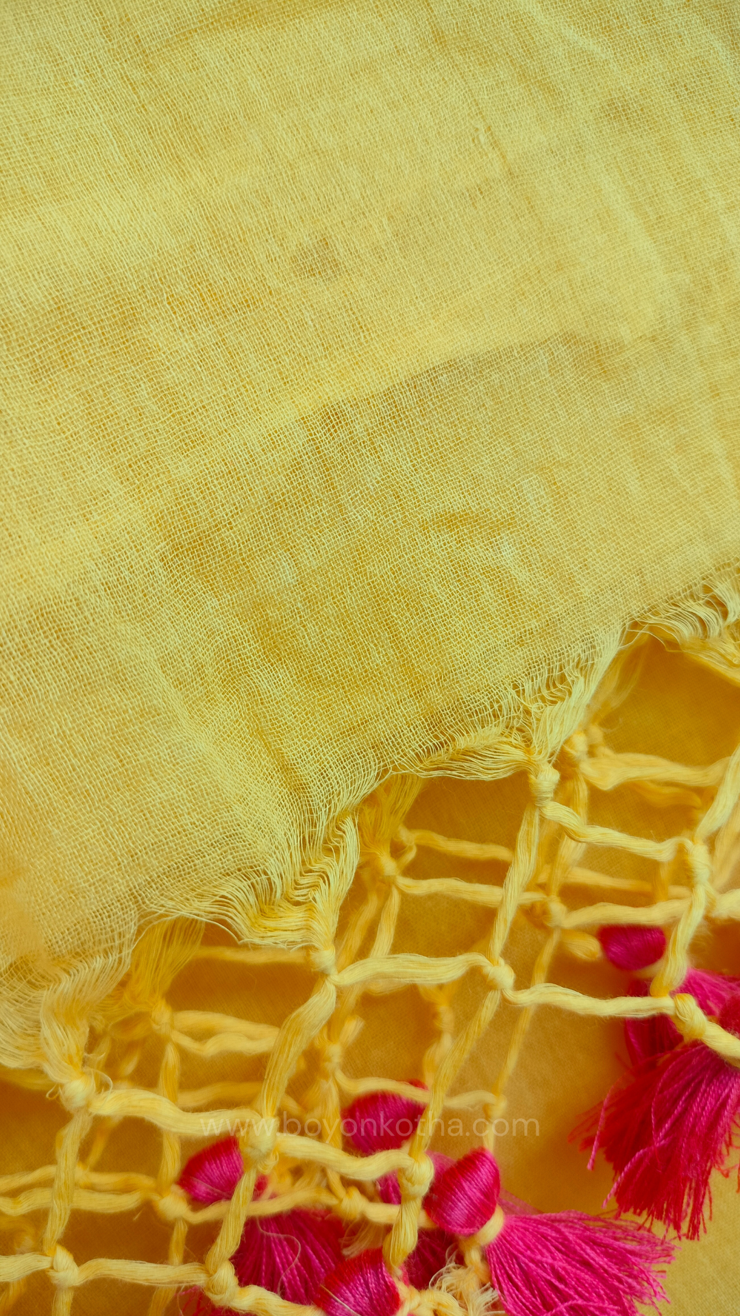 Yellow handwoven mul cotton saree with peach border, pallu ending in tassels. Plain handloom yellow saree from Bengal.