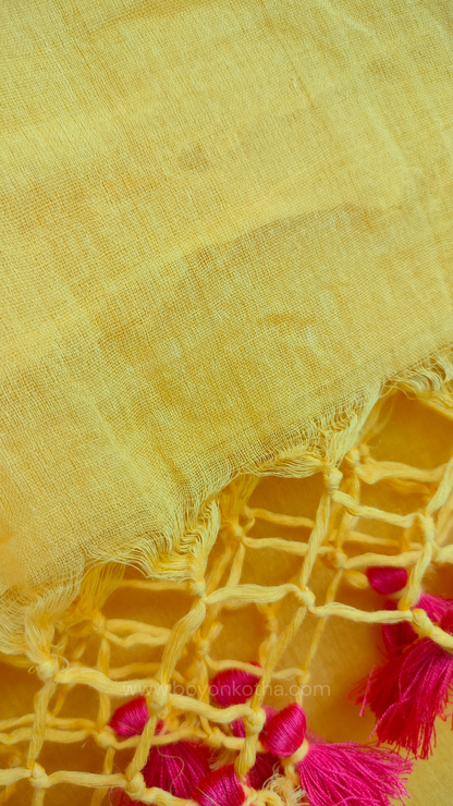 Yellow handwoven mul cotton saree with peach border, pallu ending in tassels. Plain handloom yellow saree from Bengal.