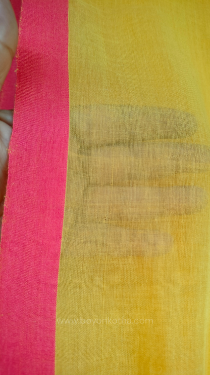 Yellow handwoven mul cotton saree with peach border, pallu ending in tassels. Plain handloom yellow saree from Bengal.
