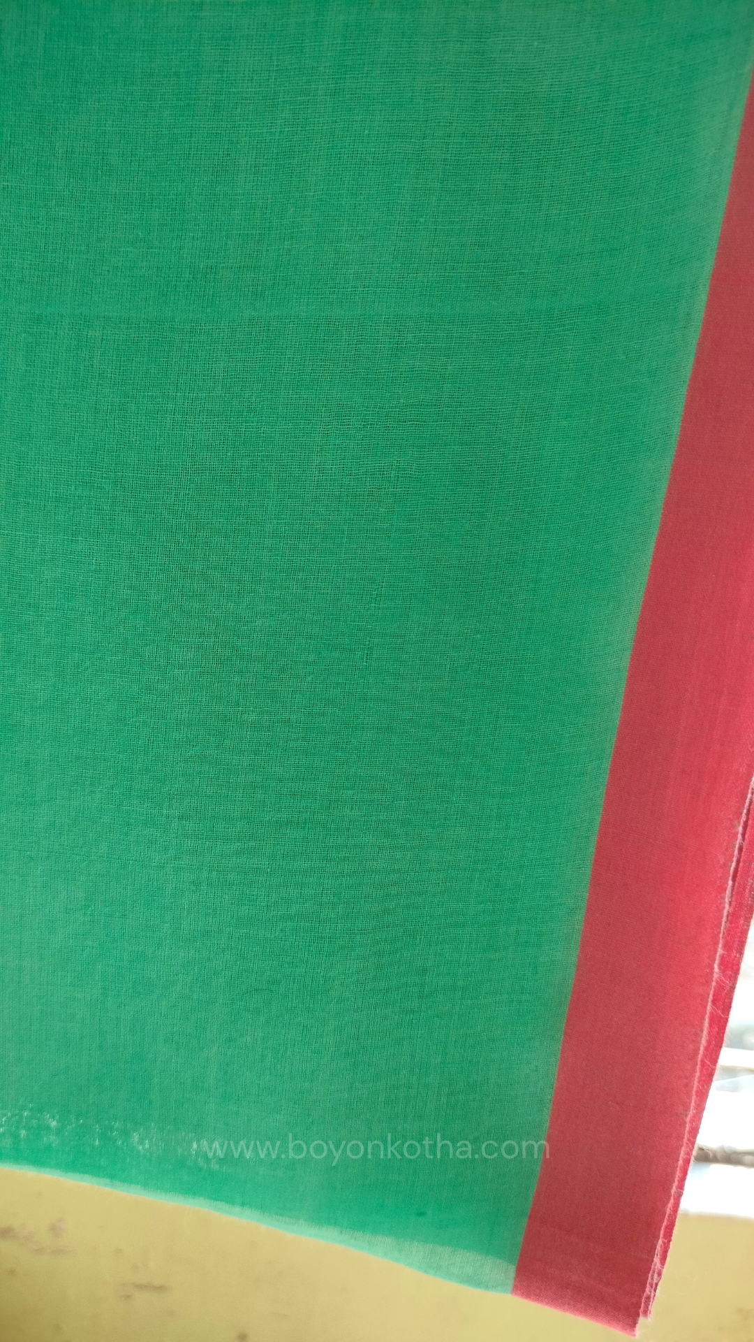 Mint green handwoven mul cotton saree with pink border, pallu ending in tassels. Plain handloom saree from Bengal.