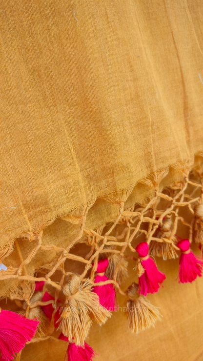 Mustard yellow handwoven mul cotton saree with red border, pallu ending in tassels. Plain handloom mustard yellow saree from Bengal.