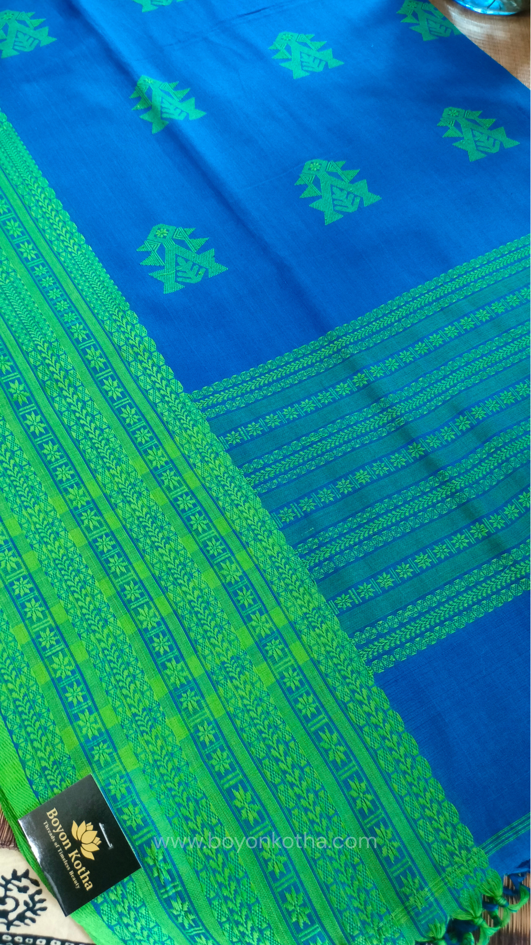 Royal blue handwoven mercerized cotton saree with Manipuri-inspired thread work pattern in green. Durable, breathable Bengal handloom saree for festive wear.