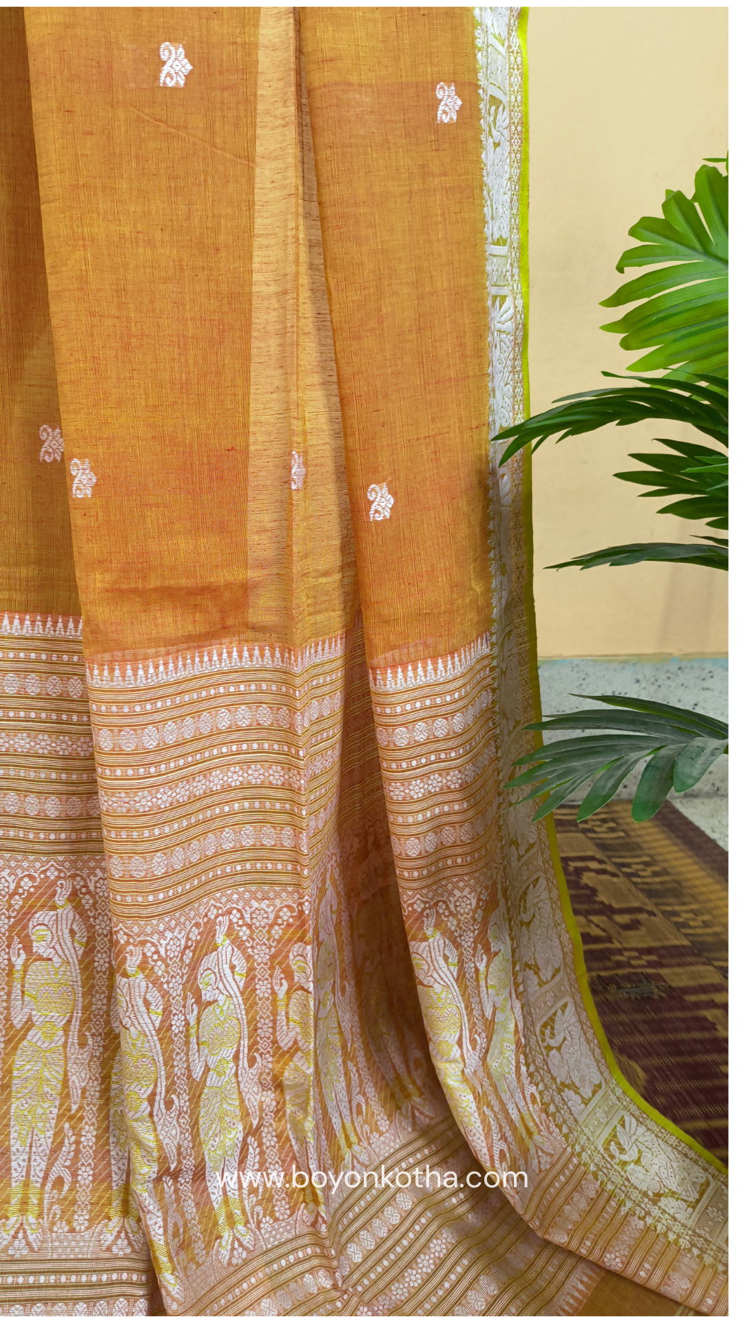 Dark orange cotton baluchari saree, with woven motifs in the border & pallu in white and neon green. Bengal handloom ideal for festivals & everyday celebrations.