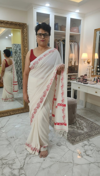 White handloom cotton saree with woven red floral vines along the border running till the pallu - Bengal handloom