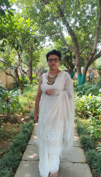 Women in white mul cotton saree with jamdani motifs standing in a garden