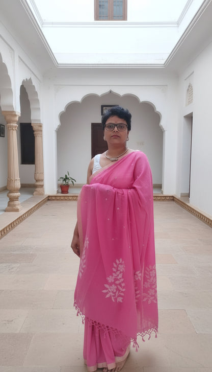 Person wearing a pink saree in a room