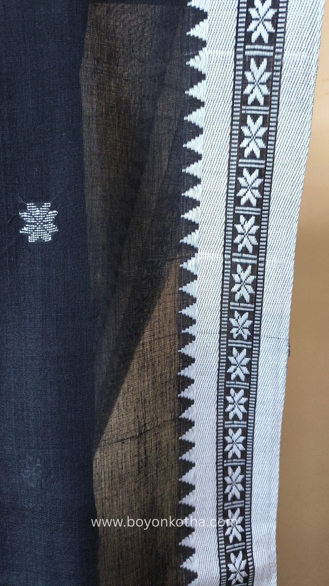 Black handloom cotton saree with white woven jamdani-inspired jacquard butis and nakshi border. Perfect for festivals and cultural gatherings.