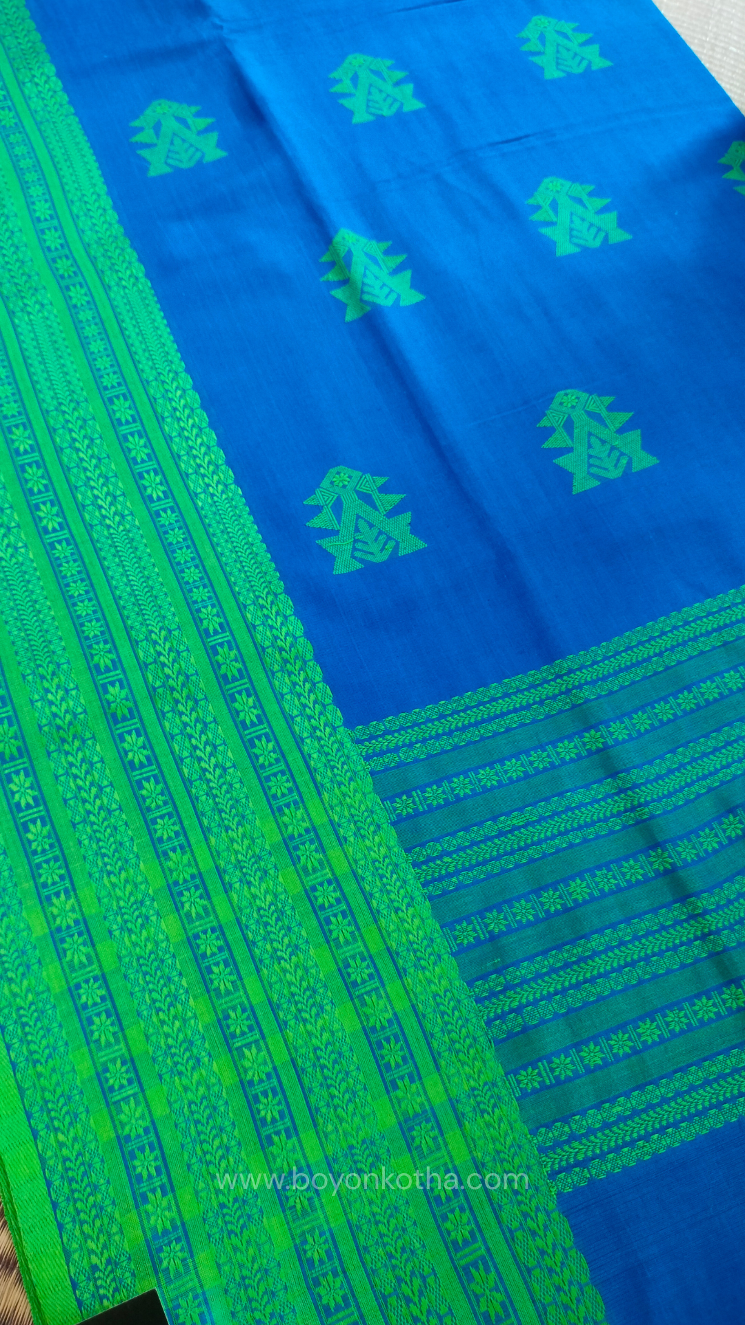 Royal blue handwoven mercerized cotton saree with Manipuri-inspired thread work pattern in green. Durable, breathable Bengal handloom saree for festive wear.