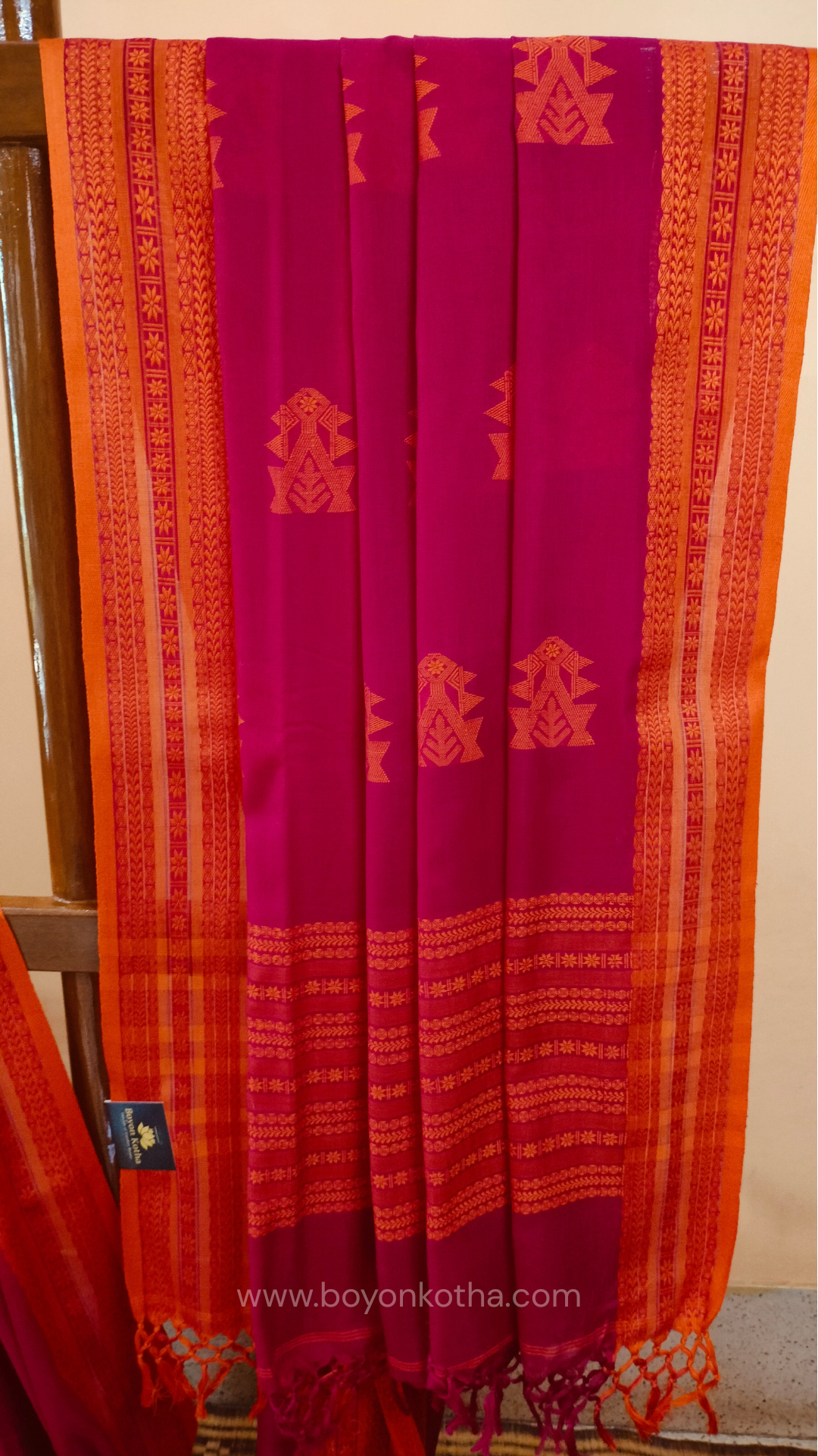 Rani Pink handwoven mercerized cotton saree with Manipuri-inspired thread work pattern in orange. Durable, breathable Bengal handloom saree for festive wear.