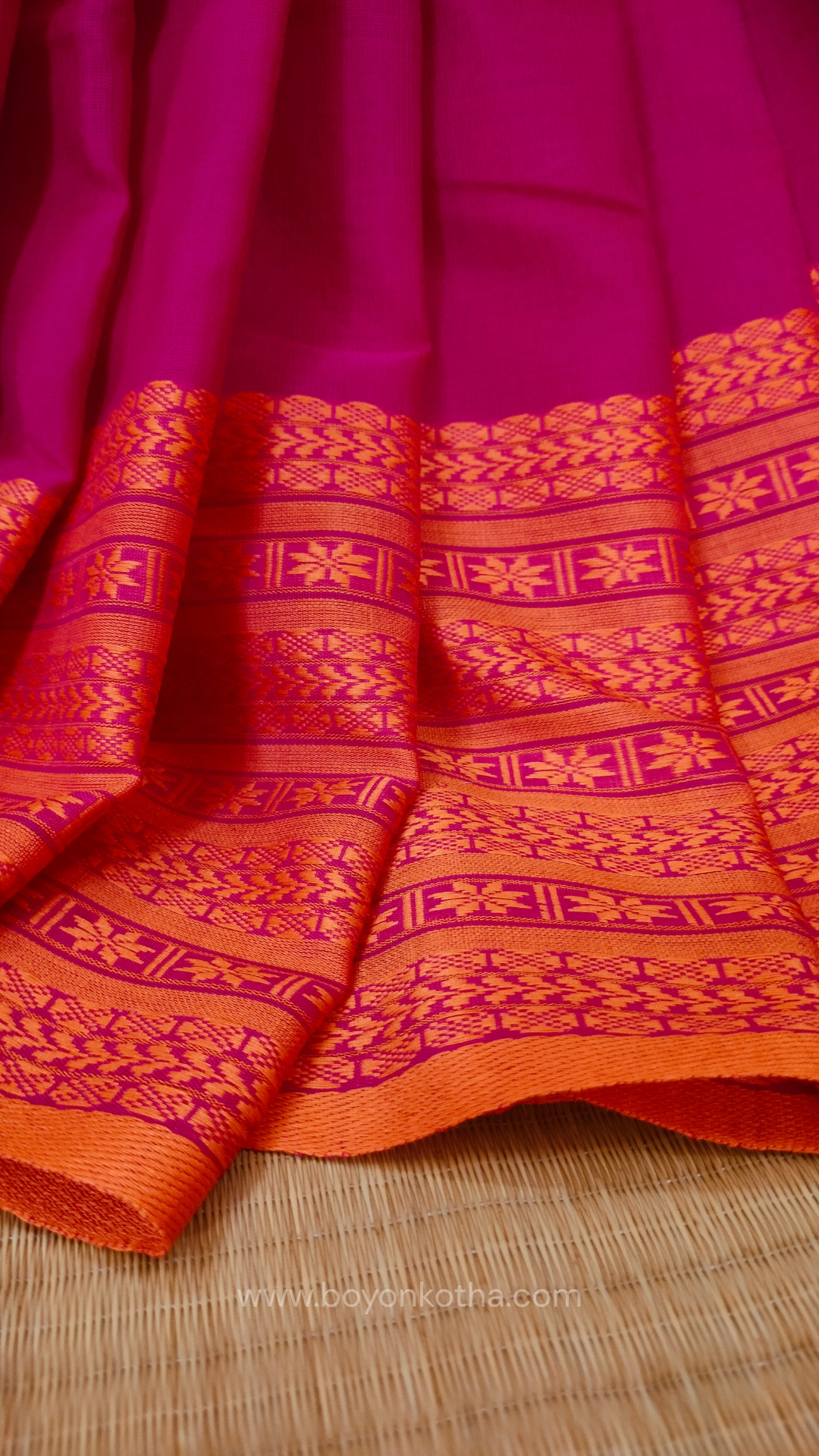 Rani Pink handwoven mercerized cotton saree with Manipuri-inspired thread work pattern in orange. Durable, breathable Bengal handloom saree for festive wear.