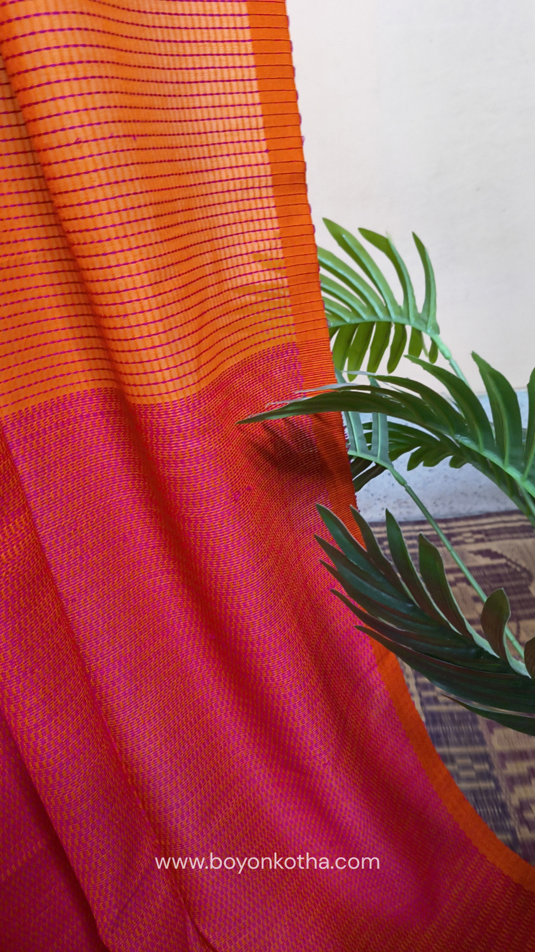 Orange handloom cotton saree with a kantha inspired weave in rani pink throughout, finished with tassels in the palla. Ideal for festivals & cultural gatherings