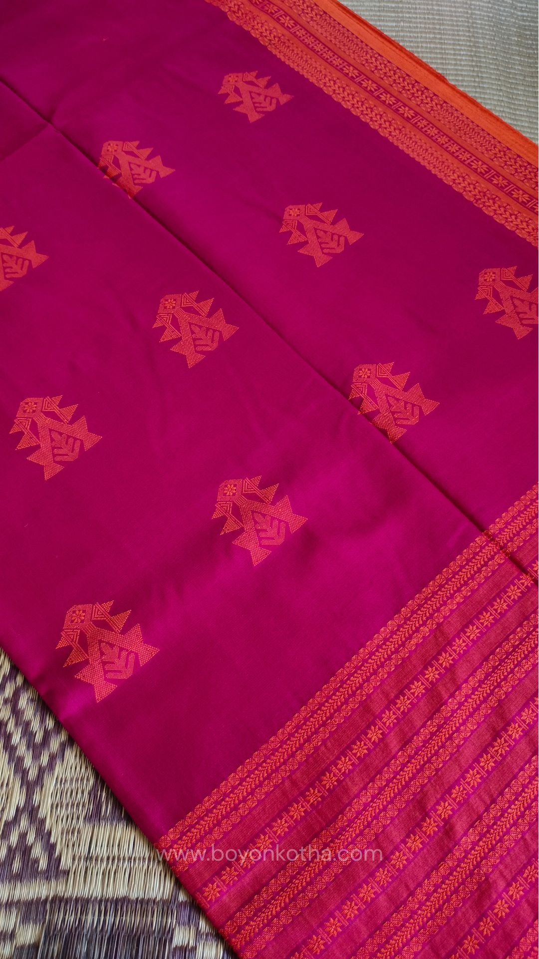 Rani Pink handwoven mercerized cotton saree with Manipuri-inspired thread work pattern in orange. Durable, breathable Bengal handloom saree for festive wear.