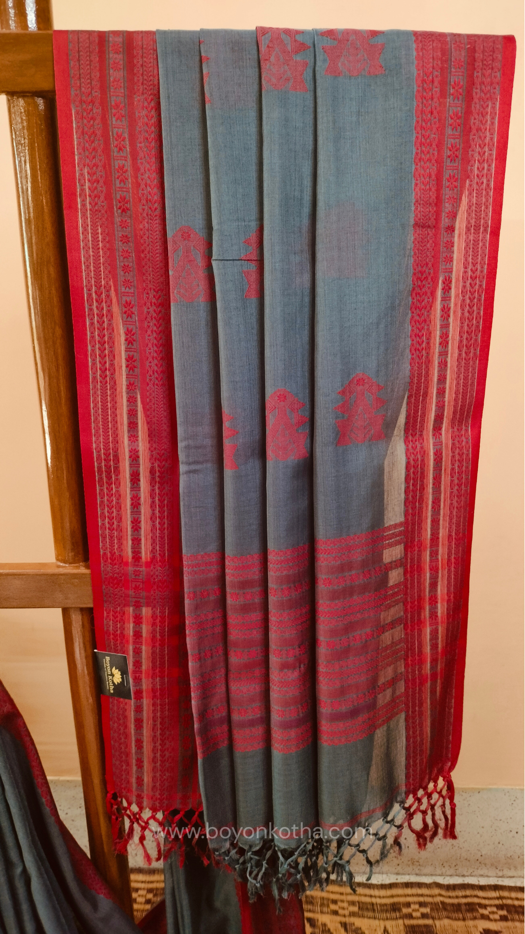 Grey handwoven mercerized cotton saree with Manipuri-inspired thread work pattern in red. Durable, breathable Bengal handloom saree for festive wear.