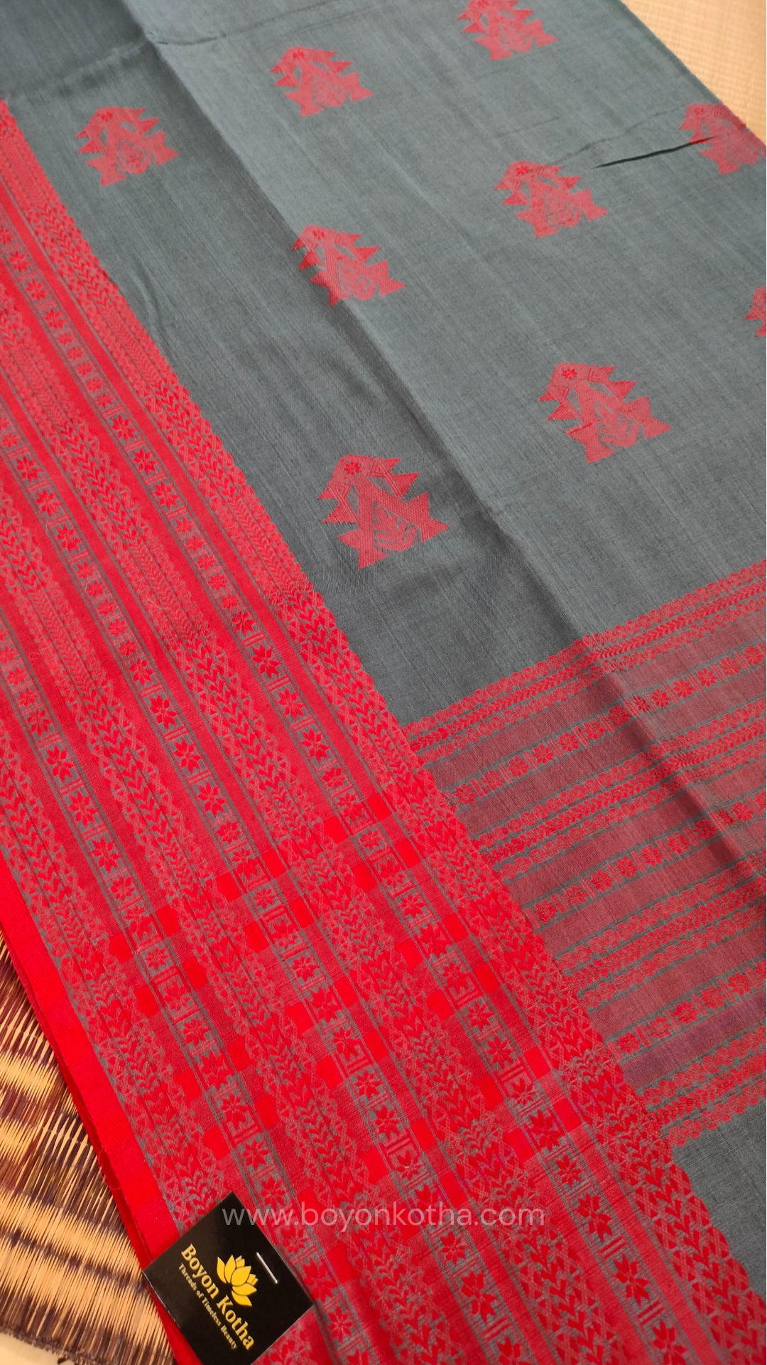 Grey handwoven mercerized cotton saree with Manipuri-inspired thread work pattern in red. Durable, breathable Bengal handloom saree for festive wear.