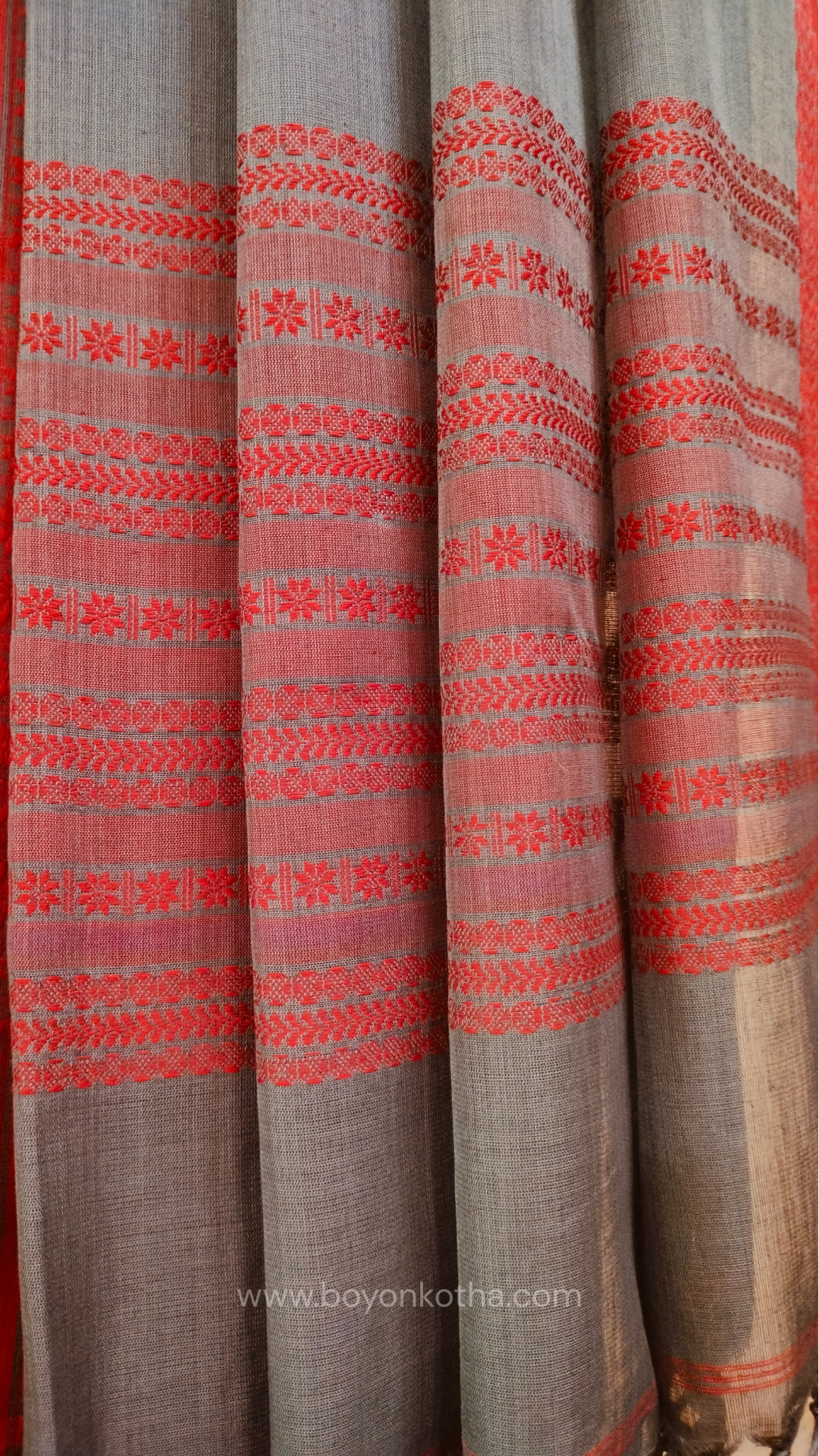 Grey handwoven mercerized cotton saree with Manipuri-inspired thread work pattern in red. Durable, breathable Bengal handloom saree for festive wear.