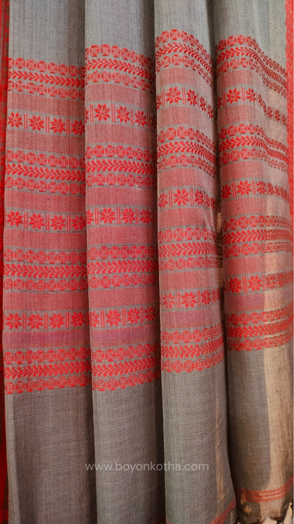 Grey handwoven mercerized cotton saree with Manipuri-inspired thread work pattern in red. Durable, breathable Bengal handloom saree for festive wear.