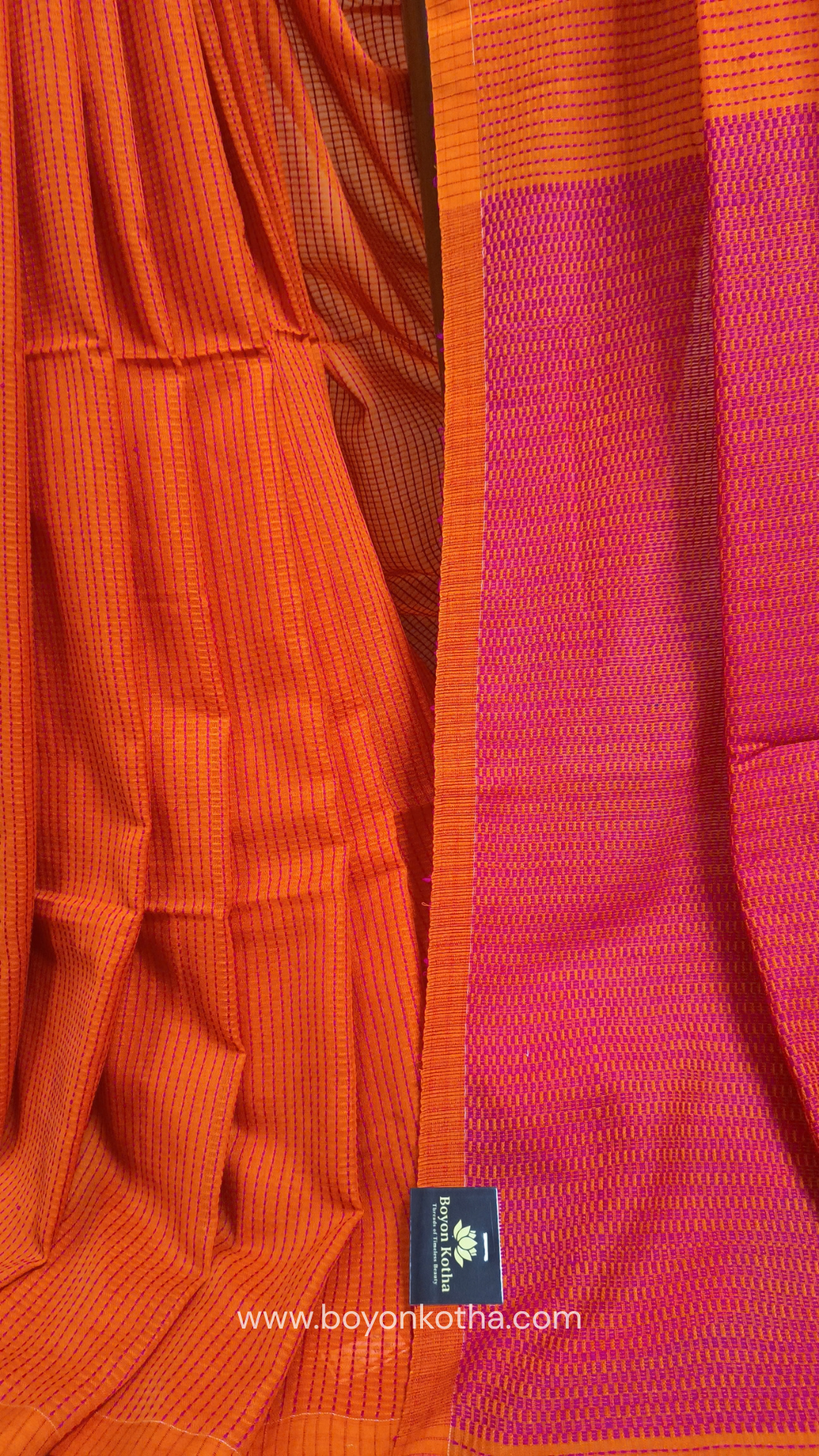 Orange handloom cotton saree with a kantha inspired weave in rani pink throughout, finished with tassels in the palla. Ideal for festivals & cultural gatherings