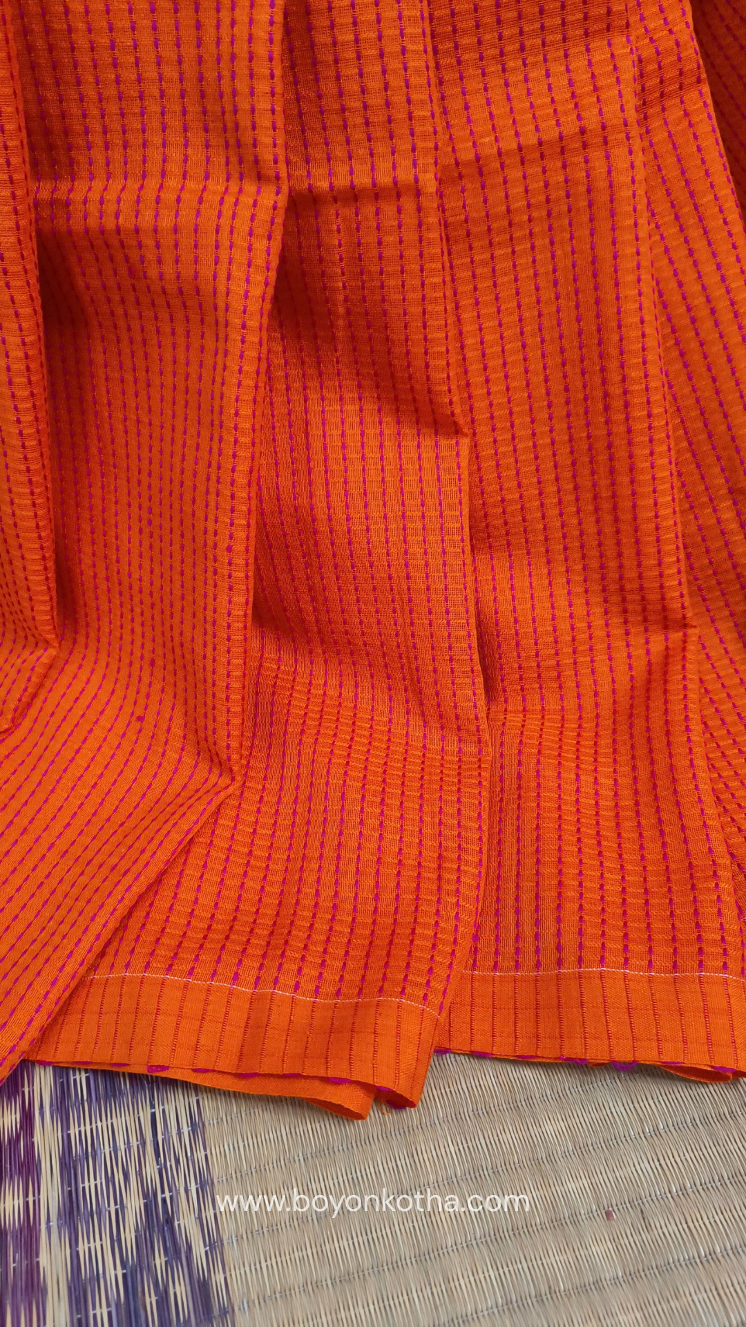 Orange handloom cotton saree with a kantha inspired weave in rani pink throughout, finished with tassels in the palla. Ideal for festivals & cultural gatherings