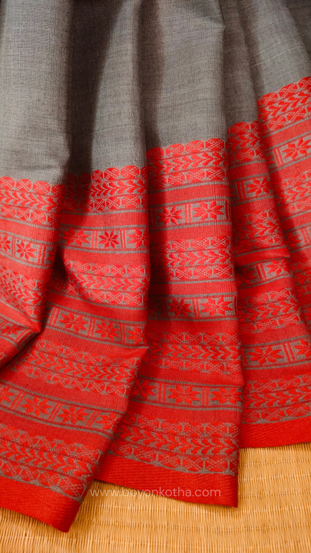 Grey handwoven mercerized cotton saree with Manipuri-inspired thread work pattern in red. Durable, breathable Bengal handloom saree for festive wear.