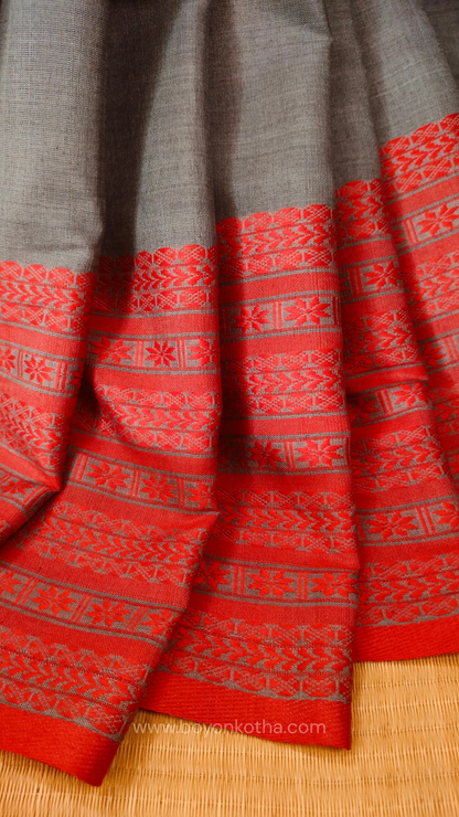 Grey handwoven mercerized cotton saree with Manipuri-inspired thread work pattern in red. Durable, breathable Bengal handloom saree for festive wear.