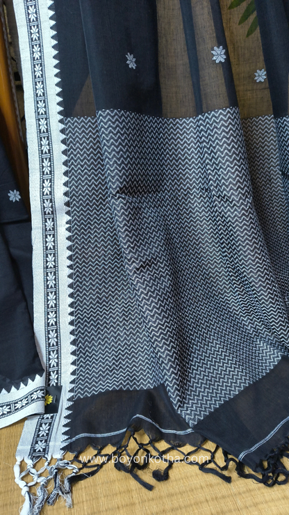 Black handloom cotton saree with white woven jamdani-inspired jacquard butis and nakshi border. Perfect for festivals and cultural gatherings.