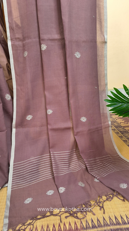 Mauvish Brown buttery soft handloom cotton saree, with jamdani inspired handloom jacquard woven butas all over and braided tassels. Ideal for festive mornings 