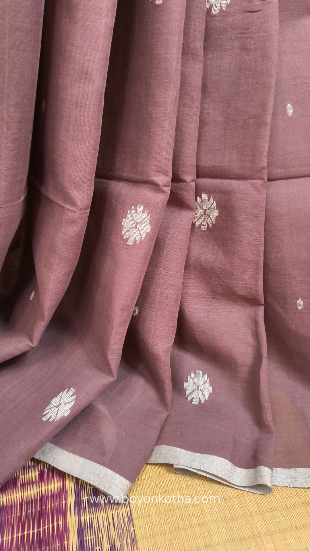 Mauvish Brown buttery soft handloom cotton saree, with jamdani inspired handloom jacquard woven butas all over and braided tassels. Ideal for festive mornings 