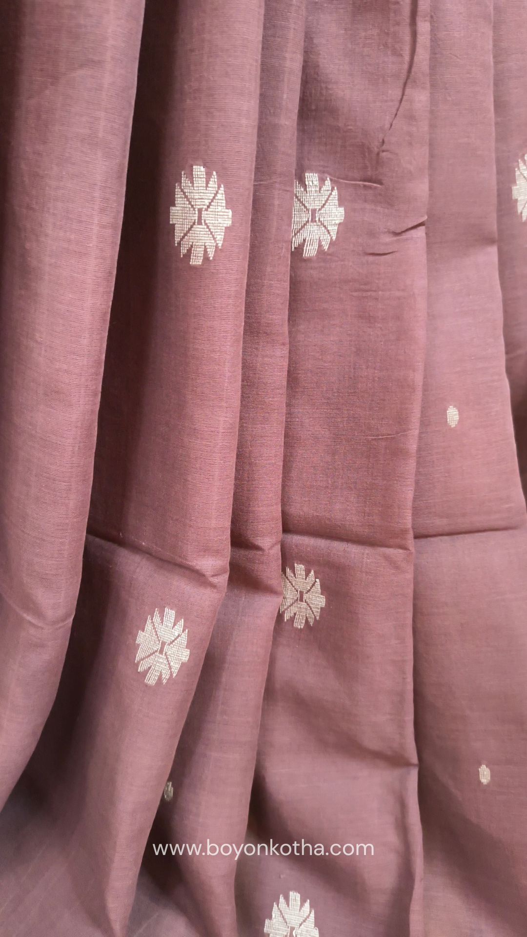 Mauvish Brown buttery soft handloom cotton saree, with jamdani inspired handloom jacquard woven butas all over and braided tassels. Ideal for festive mornings 