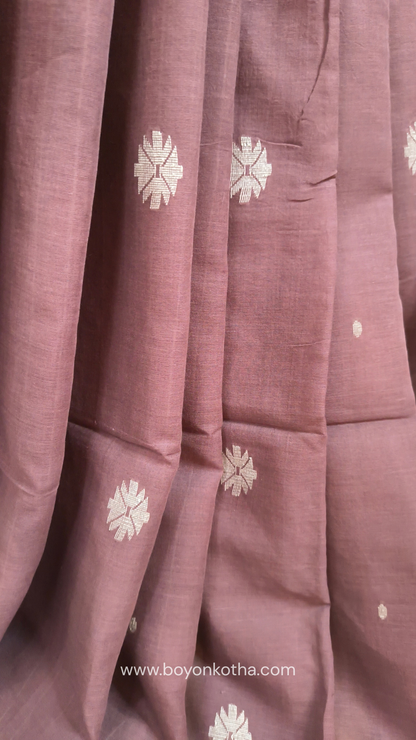 Mauvish Brown buttery soft handloom cotton saree, with jamdani inspired handloom jacquard woven butas all over and braided tassels. Ideal for festive mornings 
