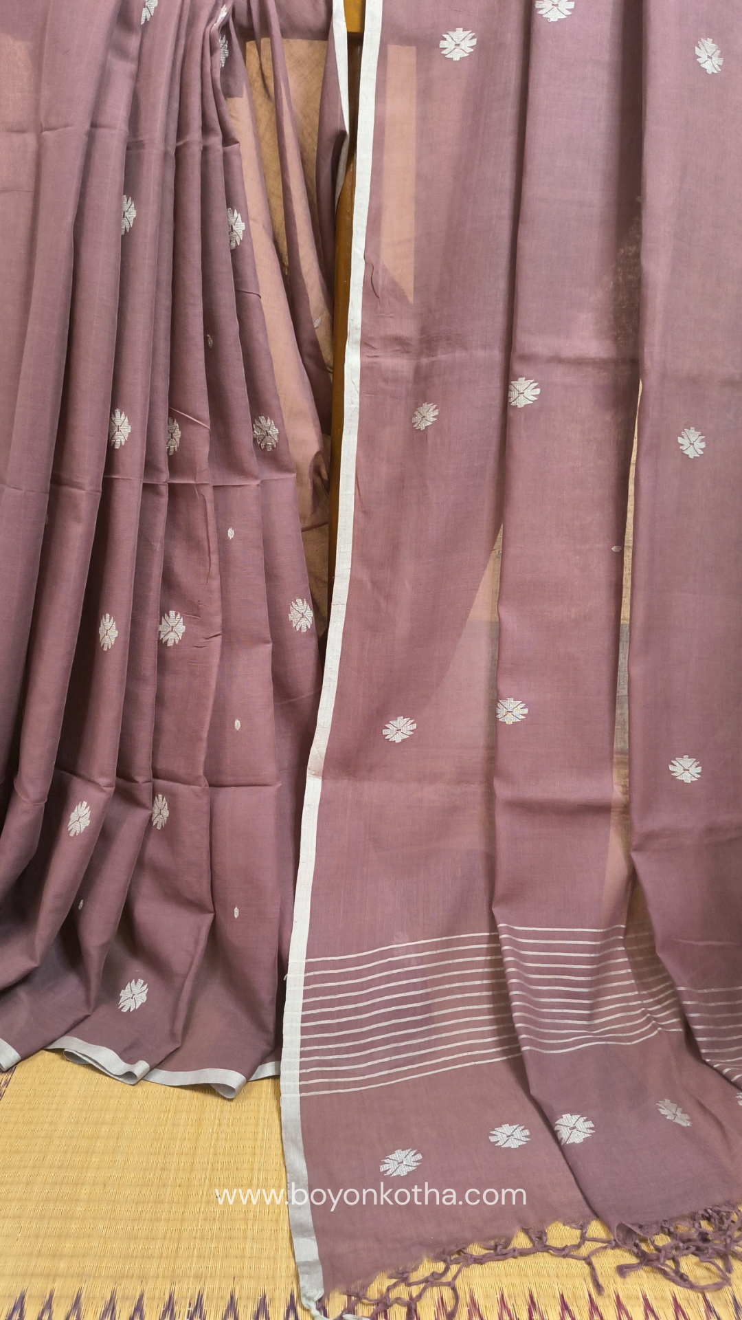 Mauvish Brown buttery soft handloom cotton saree, with jamdani inspired handloom jacquard woven butas all over and braided tassels. Ideal for festive mornings 