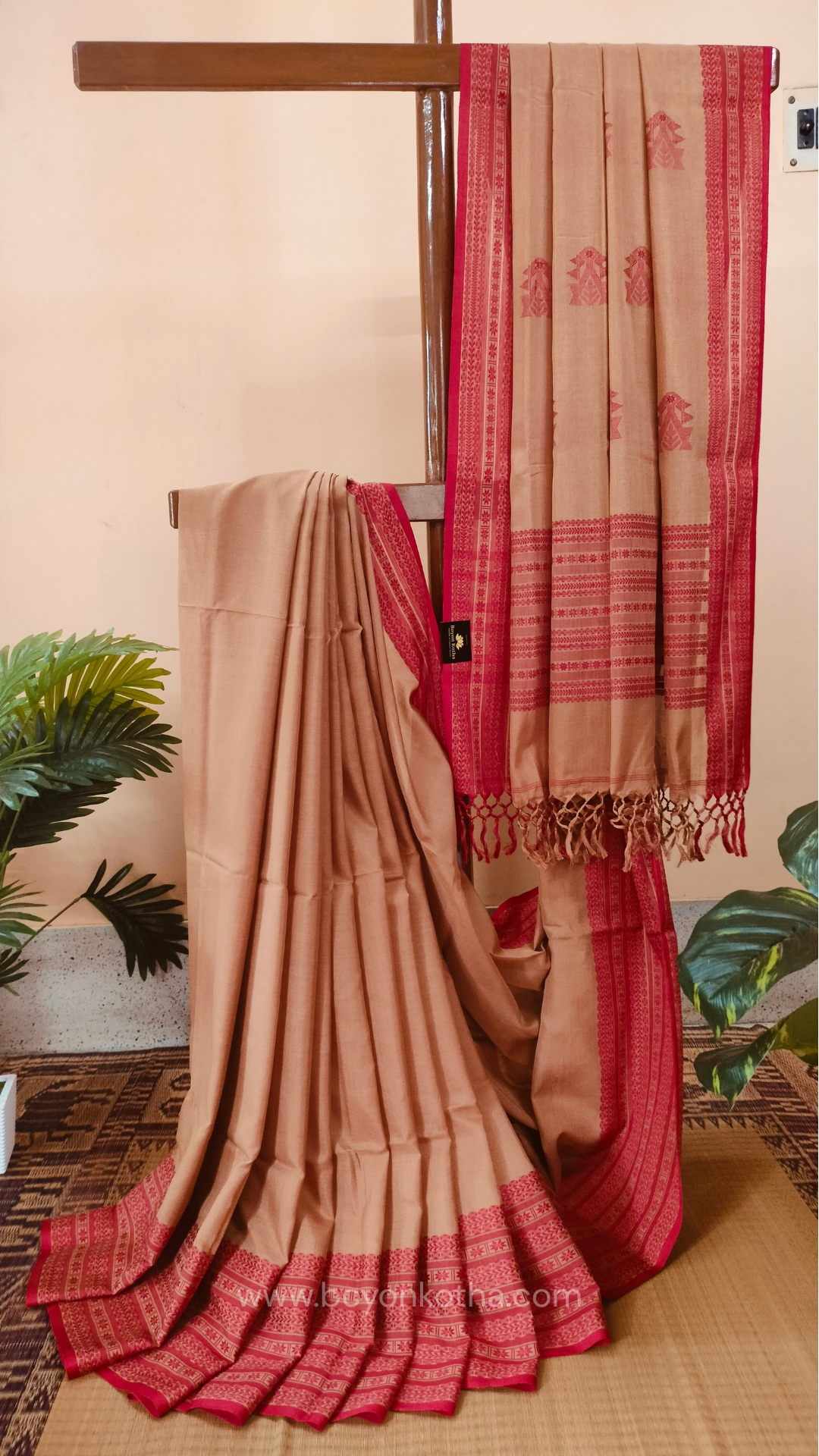 Beige handwoven mercerized cotton saree with Manipuri-inspired thread work pattern in red. Durable, breathable Bengal handloom saree for festive wear.