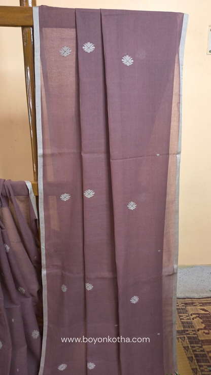Mauvish Brown buttery soft handloom cotton saree, with jamdani inspired handloom jacquard woven butas all over and braided tassels. Ideal for festive mornings 