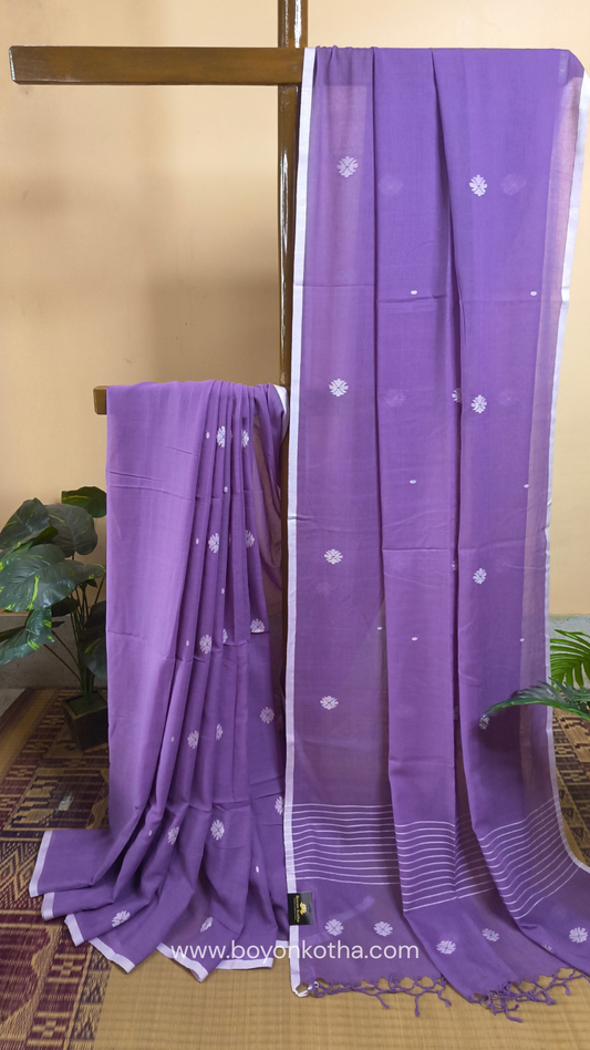 Buttery soft handloom cotton saree in lavender, with jamdani inspired handloom jacquard woven butas all over and braided tassels. Ideal for festive mornings 