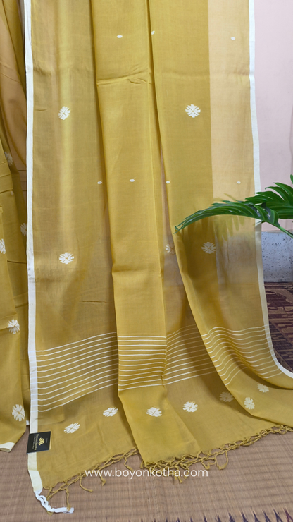 Greenish yellow buttery soft handloom cotton saree, with jamdani inspired handloom jacquard woven butas all over and braided tassels. Ideal for festive mornings 