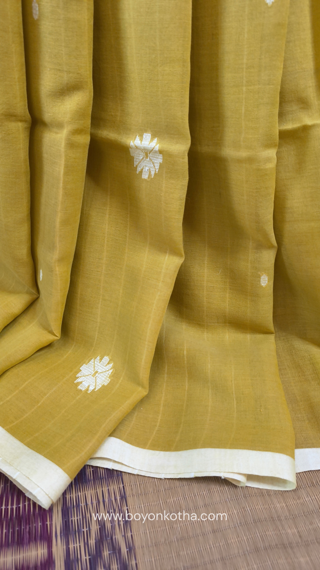 Greenish yellow buttery soft handloom cotton saree, with jamdani inspired handloom jacquard woven butas all over and braided tassels. Ideal for festive mornings 