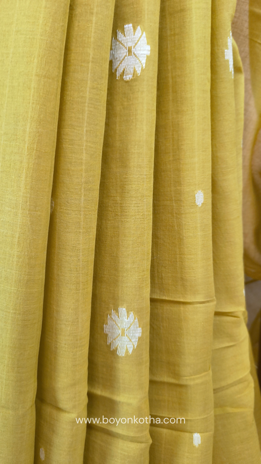 Greenish yellow buttery soft handloom cotton saree, with jamdani inspired handloom jacquard woven butas all over and braided tassels. Ideal for festive mornings 