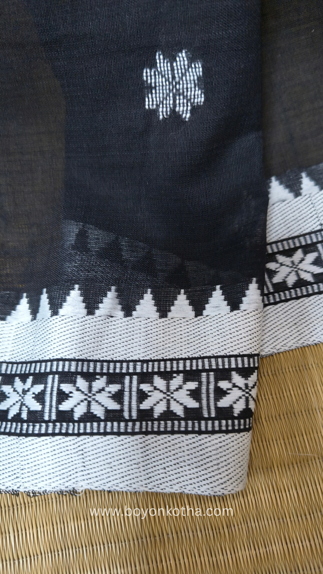Black handloom cotton saree with white woven jamdani-inspired jacquard butis and nakshi border. Perfect for festivals and cultural gatherings.