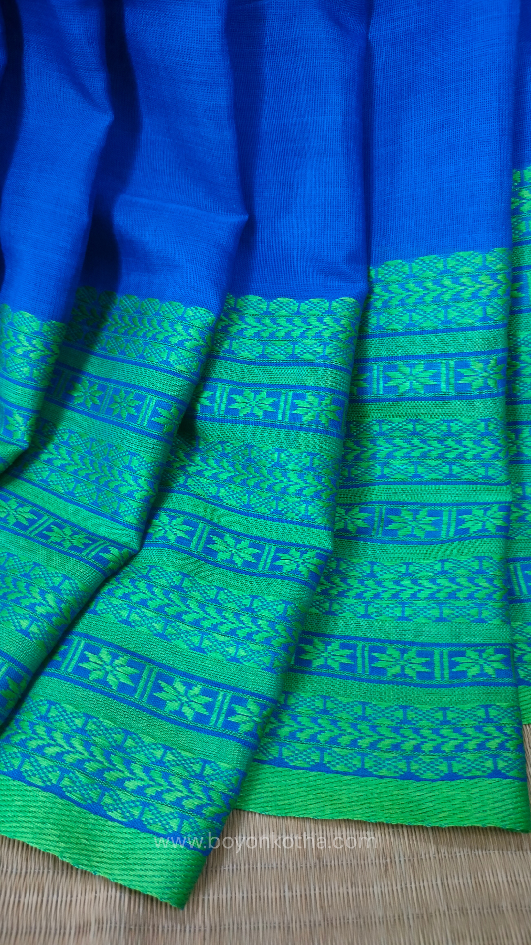 Royal blue handwoven mercerized cotton saree with Manipuri-inspired thread work pattern in green. Durable, breathable Bengal handloom saree for festive wear.
